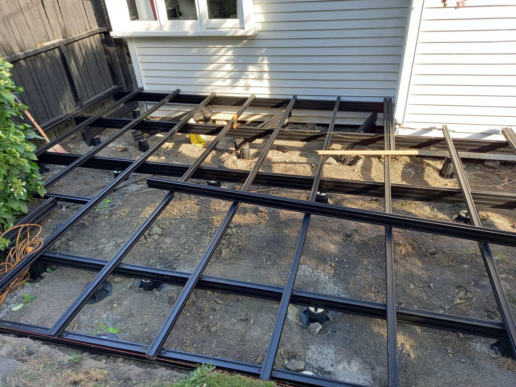 Aluminium subframe being levelled across the patio area