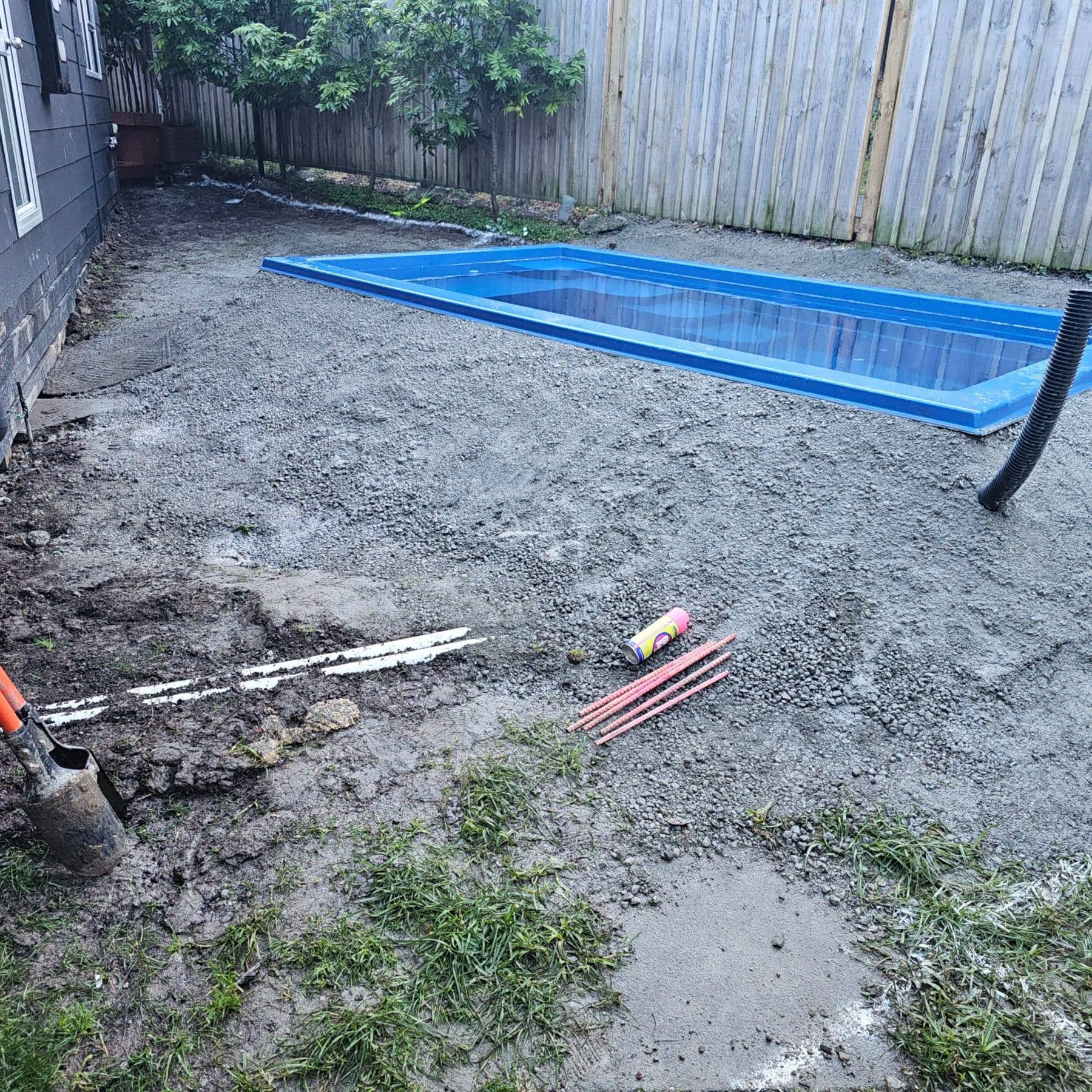 Bare gravel yard with newly installed pool shell before decking