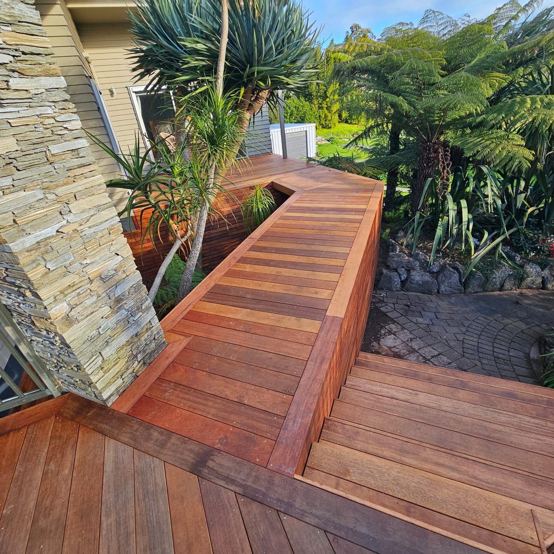 Timber bench and boards built around a stone garden wall