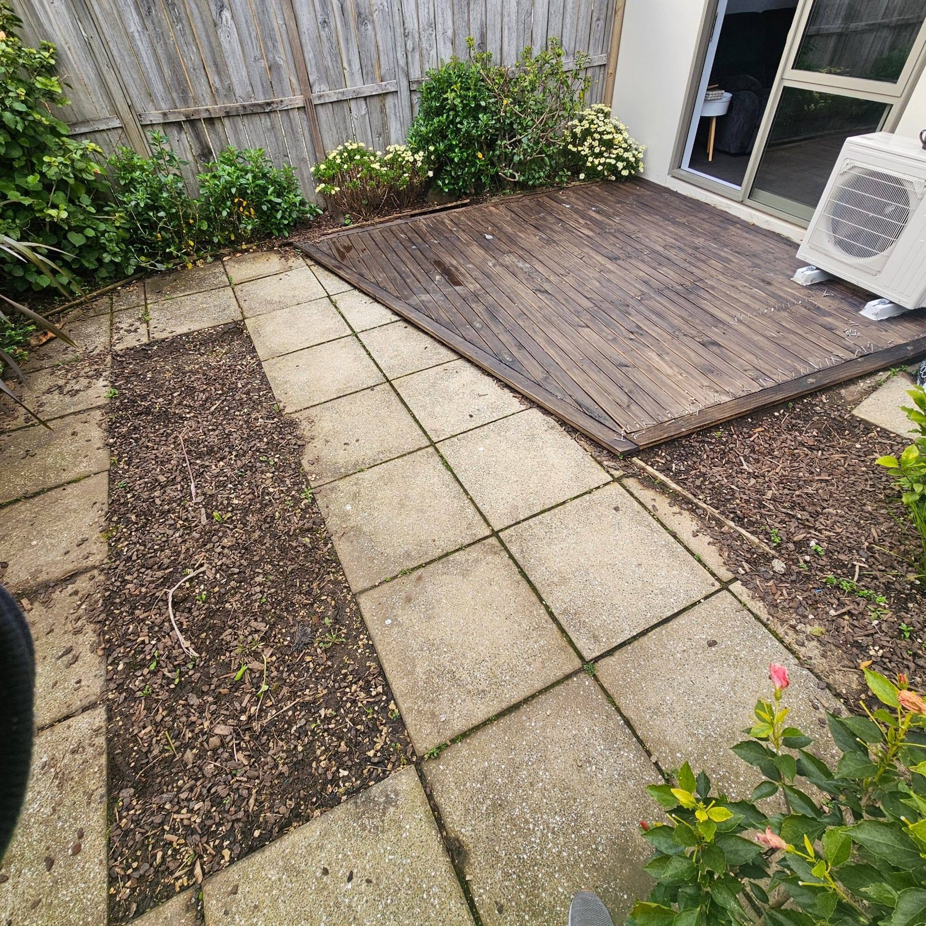 Weathered old deck and tired paving before replacement